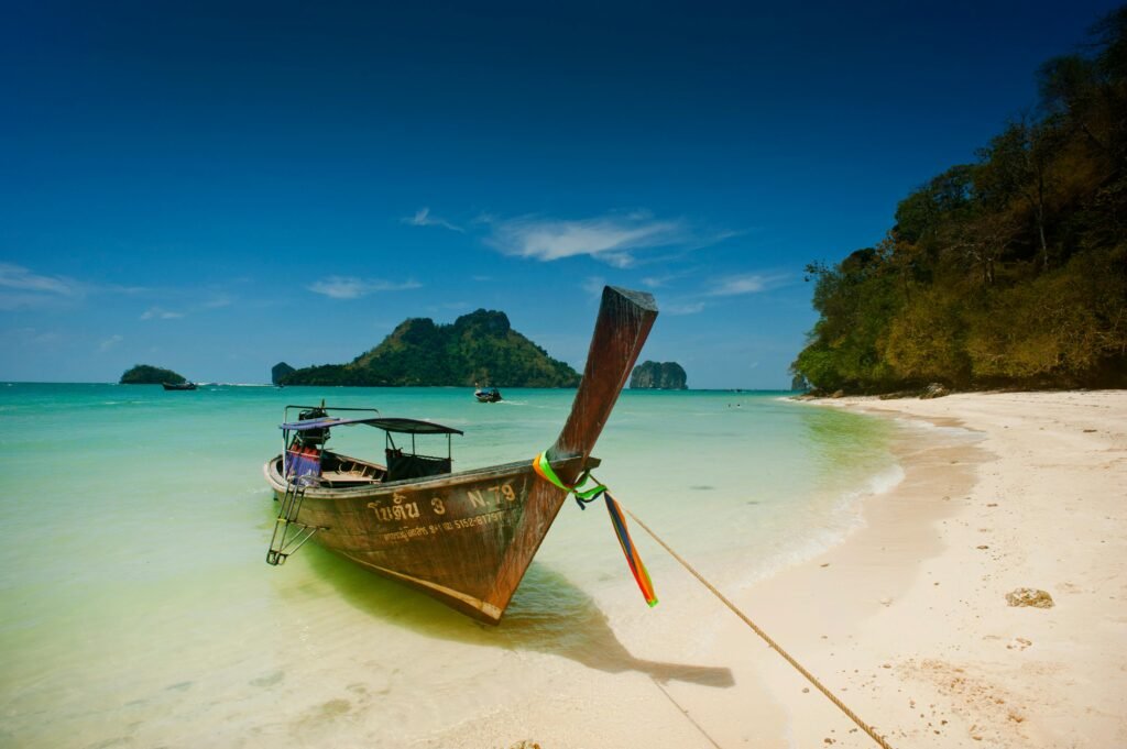 Scenic view of a traditional longtail boat on Ao Nang's turquoise beach in Krabi, Thailand.