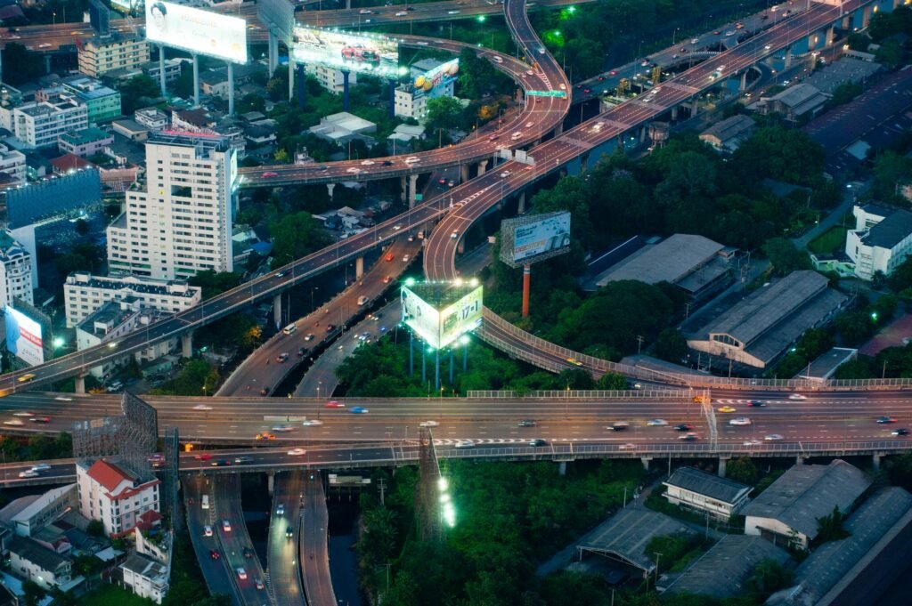 Dynamic aerial view of a bustling Bangkok expressway intersection with city lights.