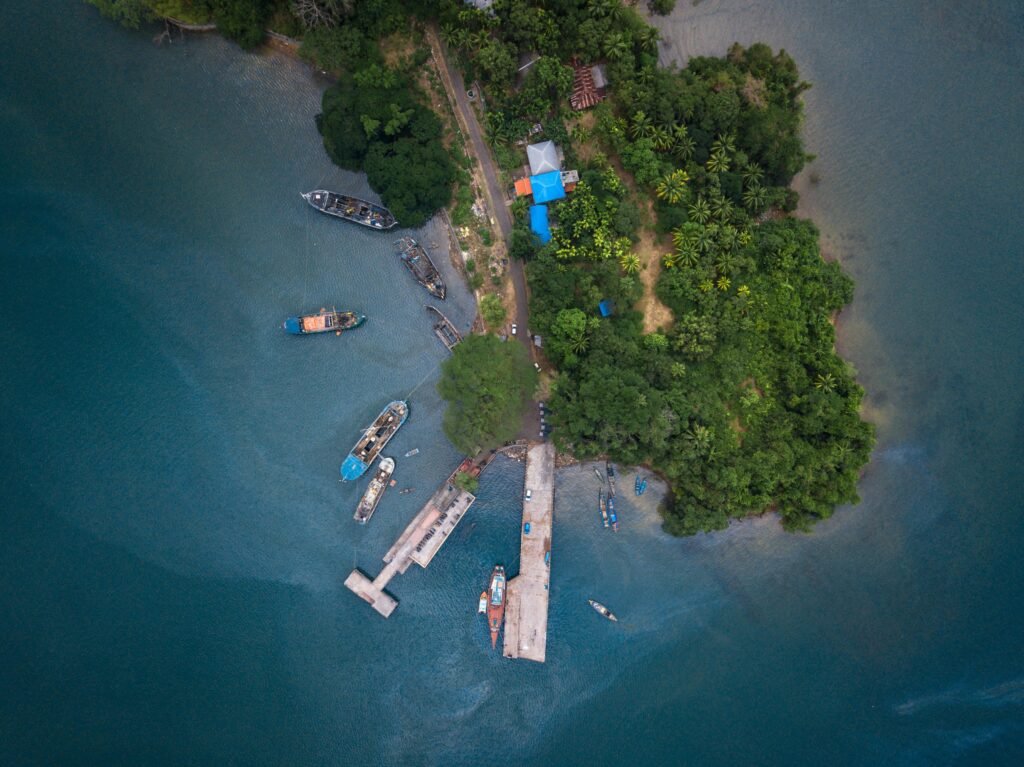 Drone capture of Port Blair's docks and boats against lush greenery and calm sea.