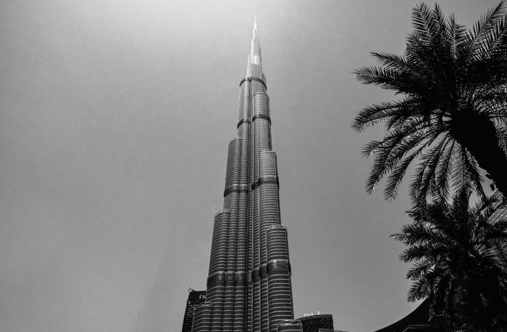 Black and white view of Burj Khalifa with palm trees, capturing Dubai's skyline elegance.