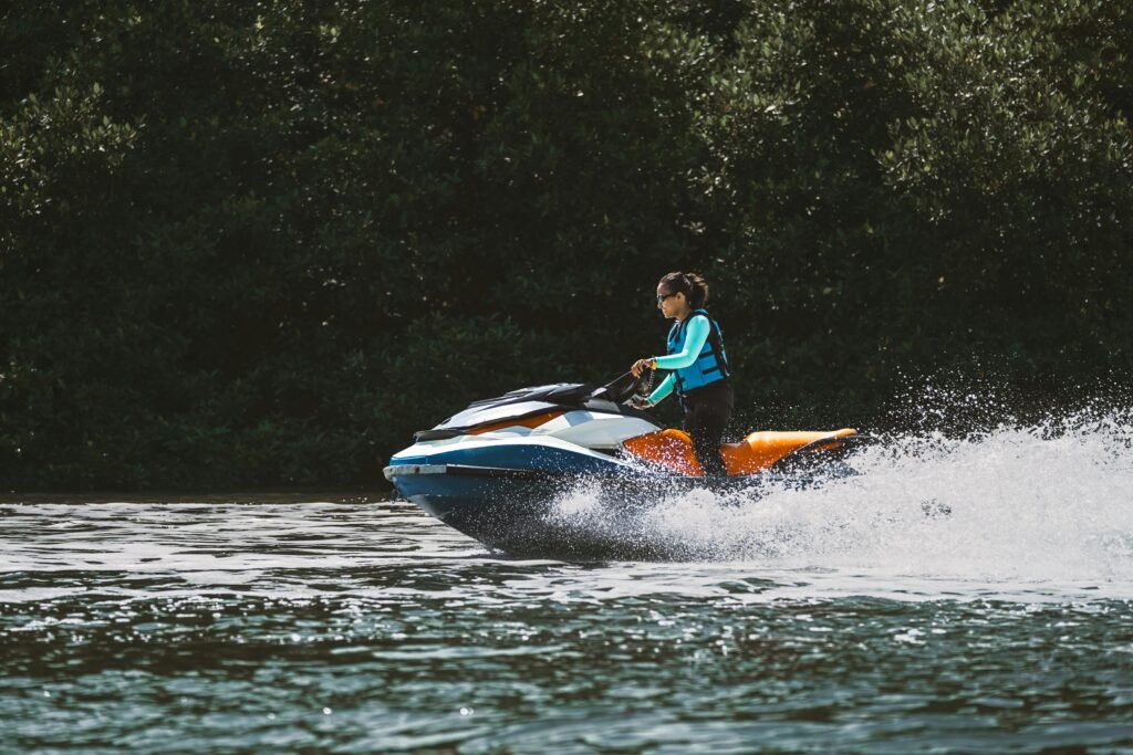 A woman rides a jet ski at high speed, creating splashes on a lake in Bali. Perfect for adventure and travel themes.