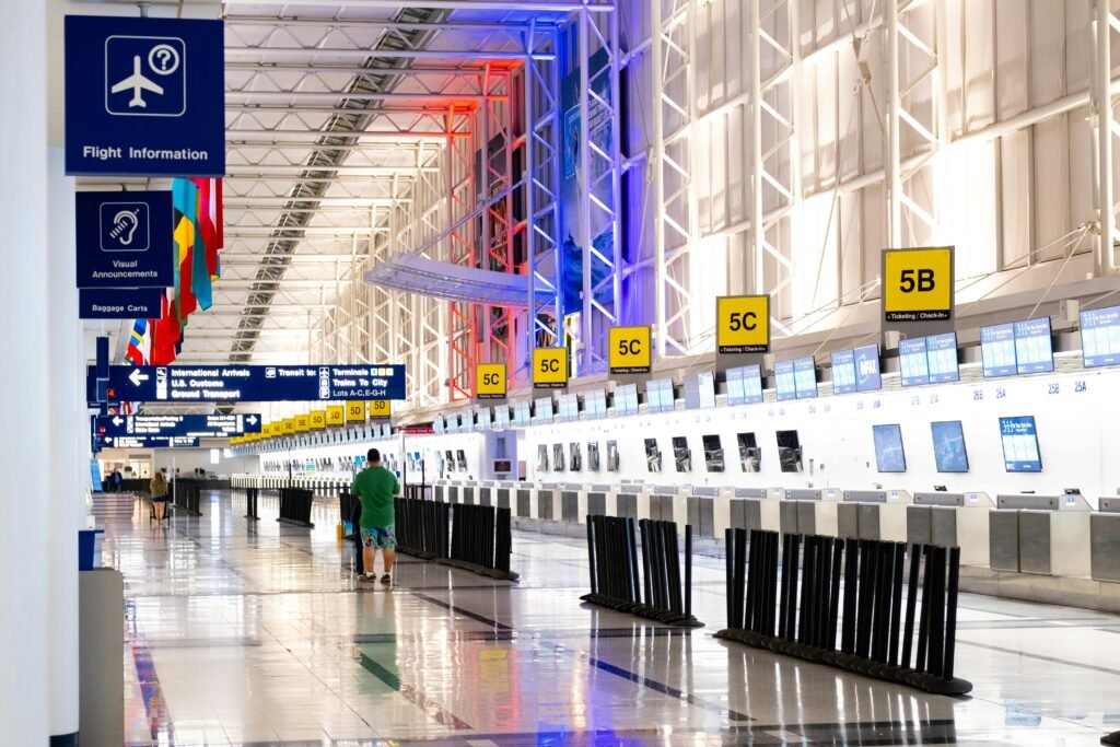 Wide view of Chicago airport terminal showcasing architecture and check-in counters. Flags and signages add vibrant detail.