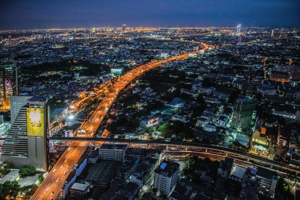 A stunning aerial view of Bangkok at night, showcasing the illuminated skyline and bustling urban life.