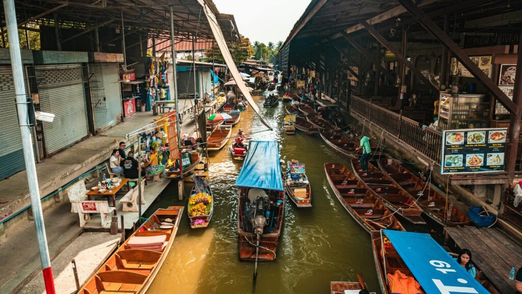 Bustling floating market in Bangkok with colorful boats and traditional vendors along the canal.