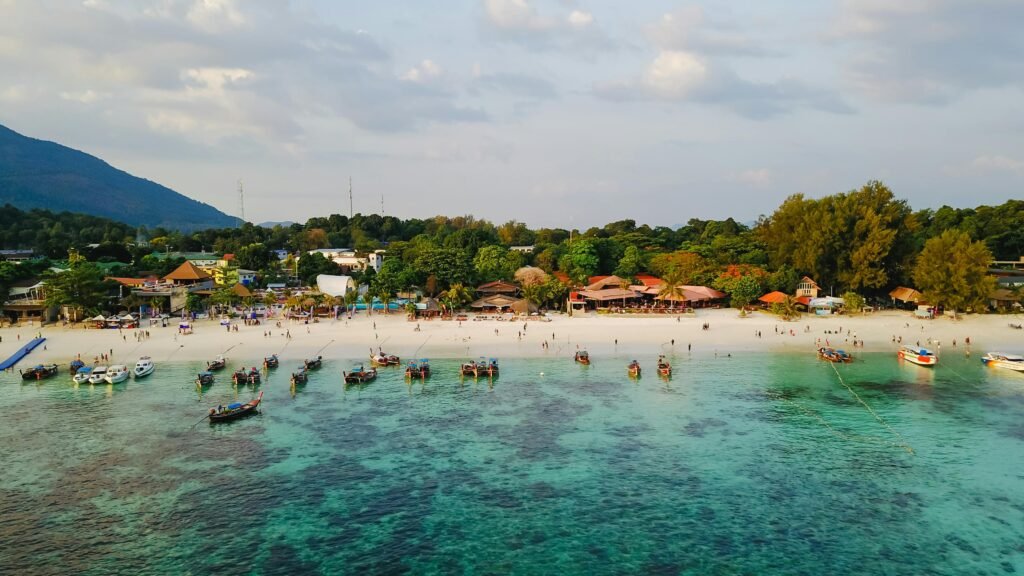 A beautiful aerial view of a tropical beach with boats and lush greenery, ideal for vacation.