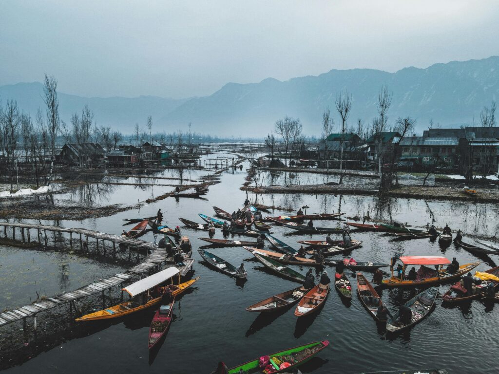 Serene floating market with boats on a calm, picturesque lake surrounded by mountains.