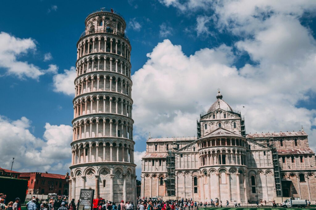 pexels-photo-1144276-1144276 The Leaning Tower of Pisa and Cathedral with tourists and vibrant sky.