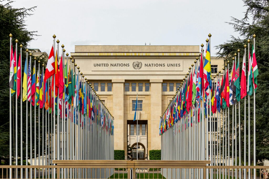 pexels-photo-16146279-16146279 View of the United Nations Office in Geneva adorned with flags of various countries.