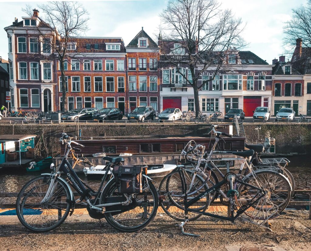 pexels-photo-3424845-3424845 Picturesque street view of Groningen featuring bicycles, canal, and historic architecture on a sunny day.